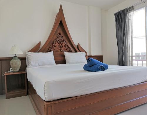 卡马拉海滩Sure Guesthouse的一间卧室配有一张大床,上面有蓝色的毛巾