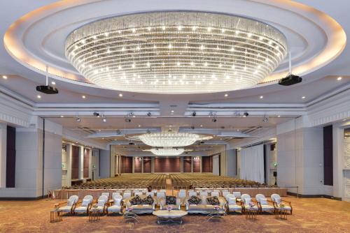 曼谷Miracle Grand Convention Hotel的一个带椅子和大吊灯的大型宴会厅