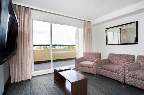 霍巴特St Ives Apartments的客厅配有两把椅子和大窗户