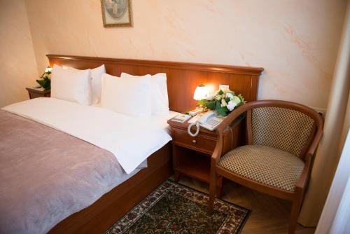 莫斯科达尼罗斯卡亚酒店的一间卧室配有一张床、一张桌子和一把椅子