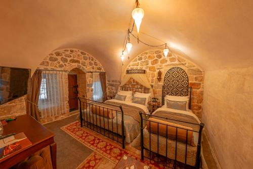 马尔丁马蒂尔斯历史酒店的石头客房设有一间带两张床的卧室