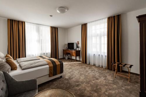 爱尔福特Haus Maximilian的酒店客房设有一张床、一台电视和窗户。