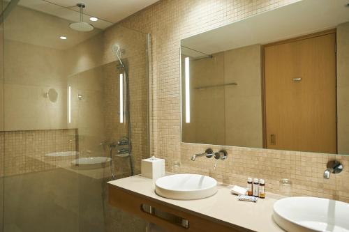 普罗塔拉斯Sunrise Jade - Adults Only的一间带两个盥洗盆和大镜子的浴室