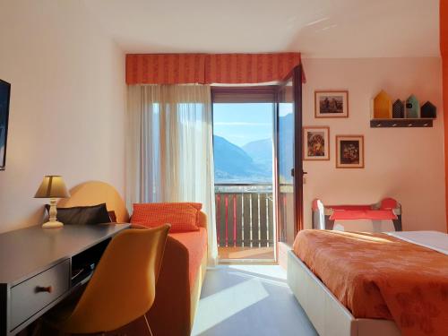 莱维科特尔梅春天家庭旅馆的一间带一张床和一张书桌的卧室以及一个阳台