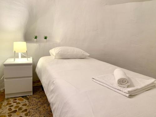 Perales de TajuñaCasa Cueva Castillo的卧室配有白色的床和毛巾