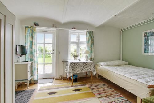 约灵Klitgaarden的一间卧室配有一张床、一张桌子和一个窗户。