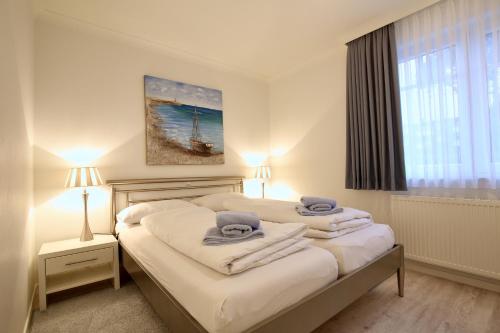 万根沃格Villa Rossini Wohnung 2的一间卧室配有两张带毛巾的床