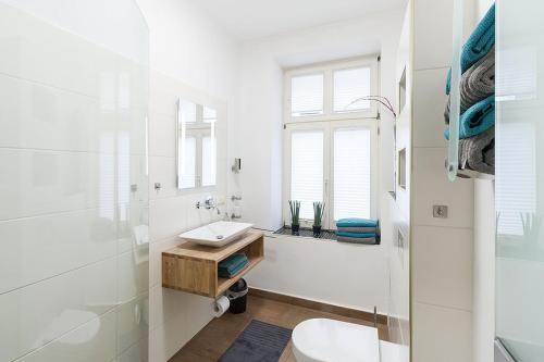 莱比锡Stilvoll & ruhig - Zentrale TOP-Lage - King Bett的白色的浴室设有水槽和卫生间。