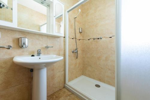 阿吉内金海滩Calypso Family的一间带水槽和淋浴的浴室