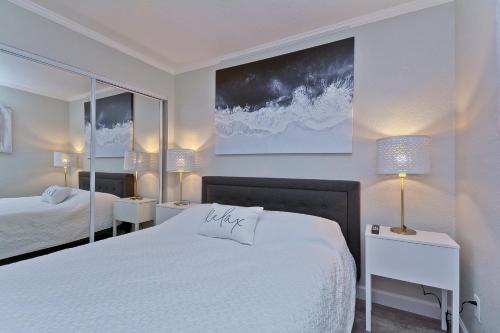 坦帕Fun and Functional Waterfront Condo - Heated Pool - WIFI的一间白色卧室,配有两张床和两盏灯。