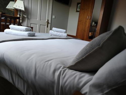 邓多克格伦加特之家旅馆的一间卧室配有两张带白色床单和枕头的床。