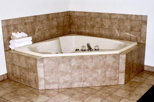 KalonaDutch Country Inn的带浴缸的浴室,铺有瓷砖地板