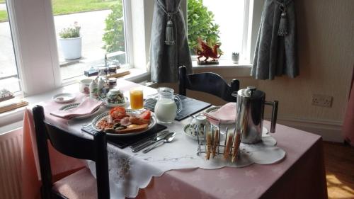 克里基厄斯Craig-y-Mor的一张桌子,上面有盘子的食物放在粉色的桌布上