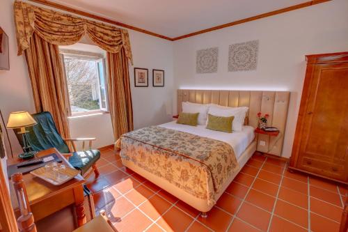 马尔旺El-Rei Dom Manuel Hotel的卧室配有床、椅子和窗户。