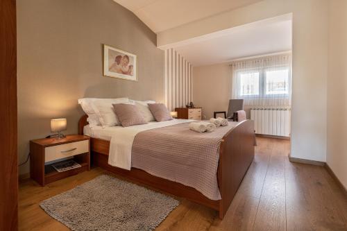 马卡尔斯卡Iva Apartment的一间卧室设有一张大床和一个窗户。