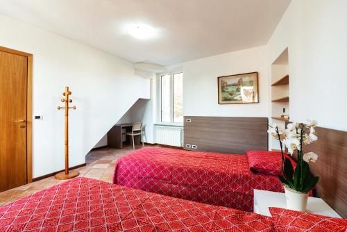 卢奇诺Il Roseto di Marina的卧室配有红色的床,墙上有十字架