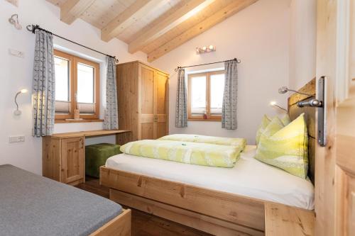 莱奥冈Ferienhaus Widauer Herzoghof的一间卧室设有一张床和两个窗户。