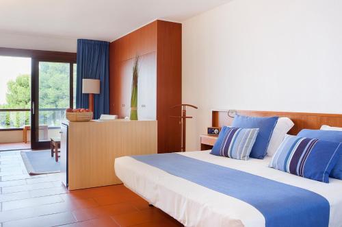 罗萨斯阿尔马德拉巴公园酒店的一间卧室配有一张带蓝白色枕头的大床
