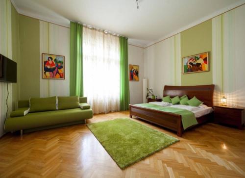 布达佩斯Spirit Nádor Ter Apartment的一间卧室配有一张床和一张绿色沙发