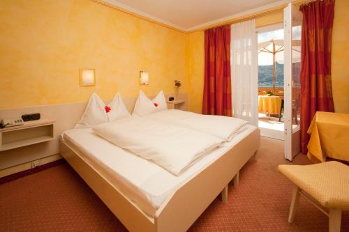 沃尔特湖畔佩莎赫圣奥斯沃德霍夫酒店的卧室设有一张白色大床和一扇窗户。