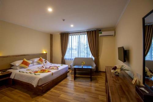 蒲甘Acacia Hotel Bagan的酒店客房带一张大床和一把椅子