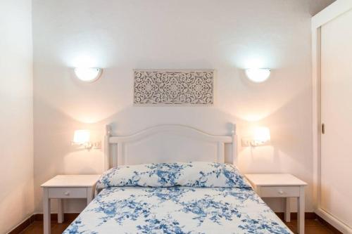 卡兰博希Chalet Cerca de la Playa的卧室配有白色的床铺,上面有蓝色的鲜花