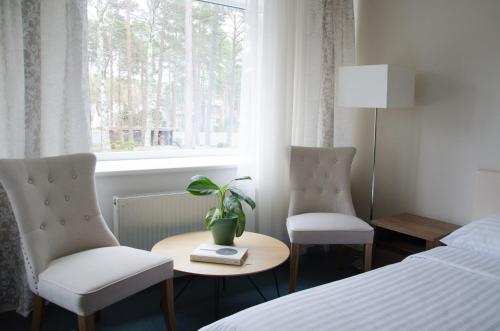 拉脱维亚Pine Resort的酒店客房设有两把椅子、一张桌子和一扇窗户。