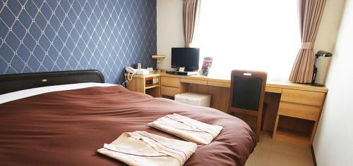 高松Takamatsu City Hotel的一间卧室配有一张床和一张带电脑的书桌