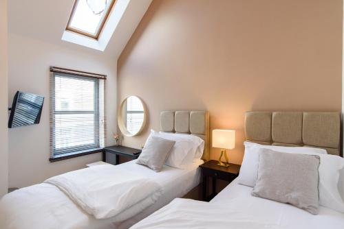 卡迪夫City Retreat, 2 Bed House with Cloudstream Hot Tub的带窗户的客房内的2张白色床