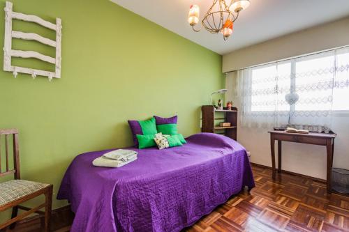 蒙得维的亚EL MEJOR LUGAR Departamento de Diseño en el mejor Barrio de Montevideo的一间卧室设有紫色的床和绿色的墙壁