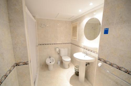 圣埃乌拉利亚梅约旅馆的一间带卫生间、水槽和镜子的浴室