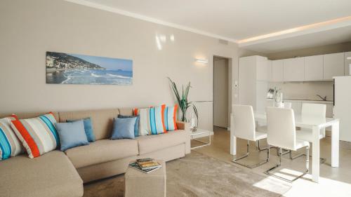 阿拉西奥Residence San Marco Suites&Apartments Alassio的带沙发的客厅和用餐室
