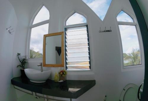 爱妮岛Franswa Inn的浴室设有水槽和窗户内的镜子