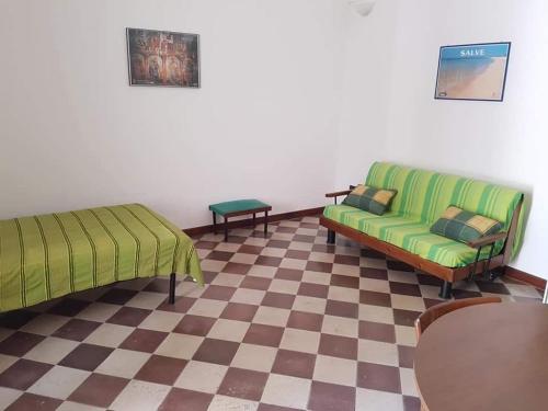 普雷西切Appartamento in Salento nel borgo di Presicce的客厅设有两张绿色沙发和一个 ⁇ 格地板