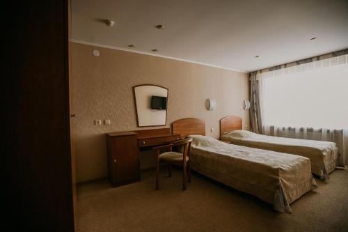 昆古尔Hotel Iren的酒店客房设有两张床、一张桌子和一面镜子