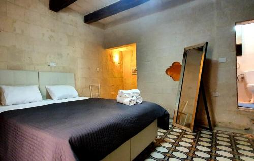 瓦莱塔Valletta Lucia Townhouse的一间卧室配有带毛巾的床