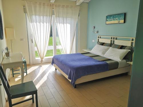 圣马赛罗泰努塔圣马赛罗酒店的一间卧室配有一张床、一张书桌和一个窗户。