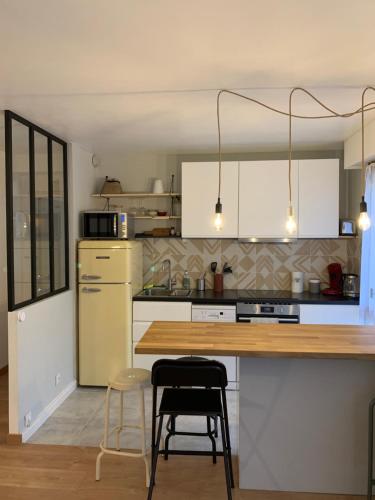 阿维尼翁T2 cosy 70s的厨房配有白色橱柜和木制台面
