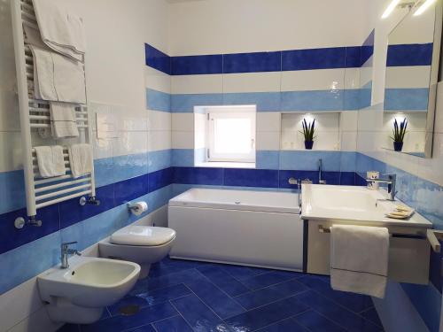 阿马尔菲Via Paradiso的蓝色和白色的浴室设有浴缸、卫生间和水槽