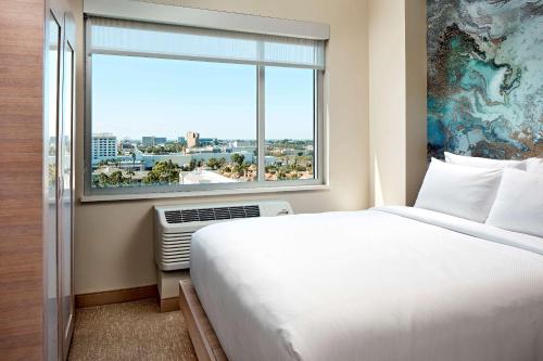 安纳海姆Cambria Hotel & Suites Anaheim Resort Area的酒店客房设有一张床和一个大窗户