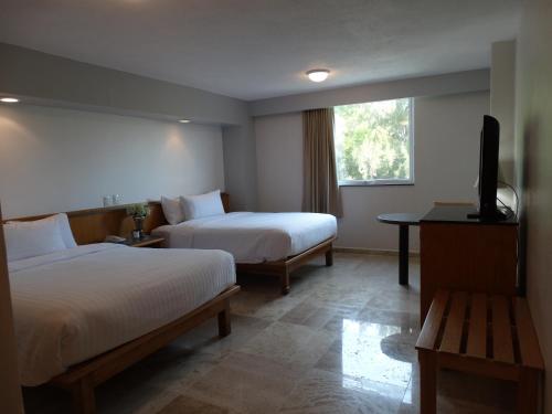 克雷塔罗Hotel Amberes的酒店客房设有两张床和一台平面电视。