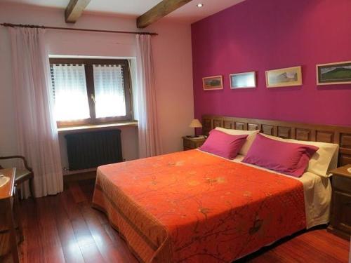 Bóveda赫拉内克斯旅馆的一间卧室设有一张紫色墙壁的大床