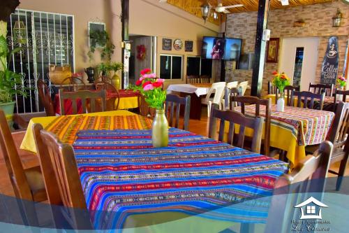 马那瓜洛斯西斯内罗斯公寓酒店的用餐室,配有一张桌子和花瓶