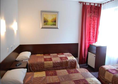 塔林Vabriku Guesthouse的酒店客房,设有两张床和红色窗帘