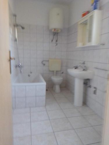 维甘Apartmani Nedjeljka的白色的浴室设有水槽和卫生间。