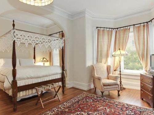 华盛顿Sojourn DuPont at The Circle的一间卧室配有一张天蓬床和一把椅子