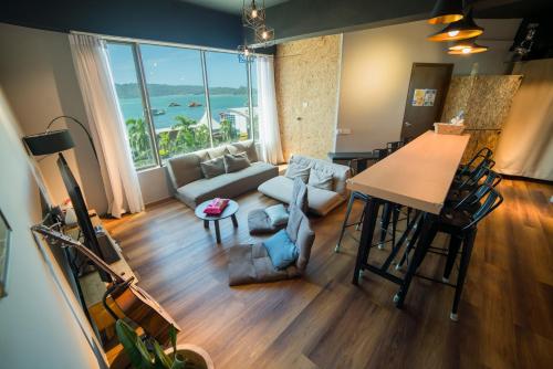 哥打京那巴鲁Homy Seafront Hostel的客厅设有沙发和美景桌子