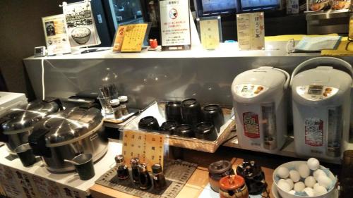 横滨伊势佐木町格兰海关胶囊旅馆的厨房配有柜台,上面有食物