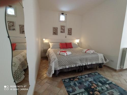 卡梅里诺La Casa di Alberto的一间卧室配有一张带红色枕头的床