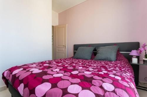 帕拉瓦莱弗洛Les Aigues Marines - belle vue mer et port的卧室配有带粉红色心的紫色床